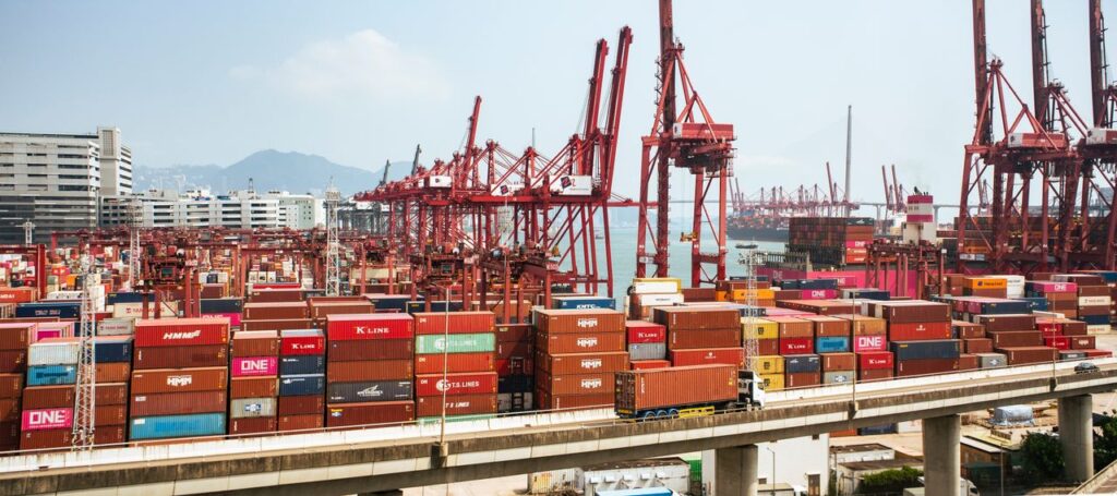pexels photo 12999283 A bustling scene of cargo containers and cranes at a Hong Kong port, showcasing global trade.