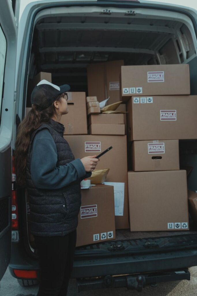 pexels photo 6169678 A female delivery worker organizing packages marked fragile in the back of a delivery van.